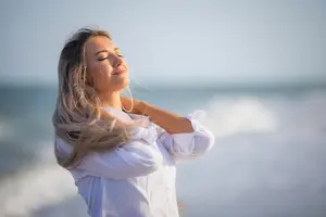 Mature woman enjoying the wellness benefits of the beach.