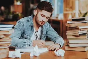 Young male writer experiencing the frustration of writers block. Binaural beats music can help him.