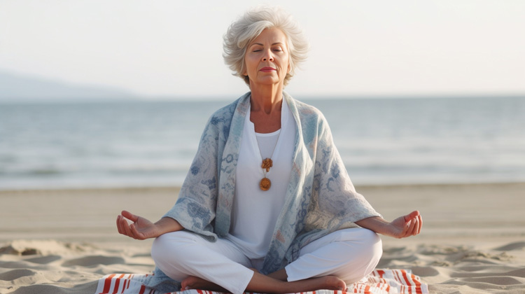 Beautiful mature woman mediates as a simple beach ritual for emotional healing. Beautiful mature woman mediates as a simple beach ritual for emotional healing.