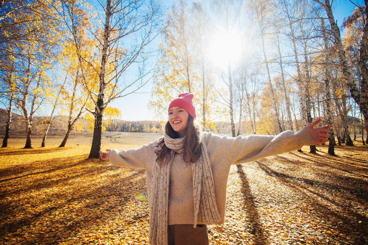 Beautiful young woman expressing happiness after a gratitude walk in the forest.