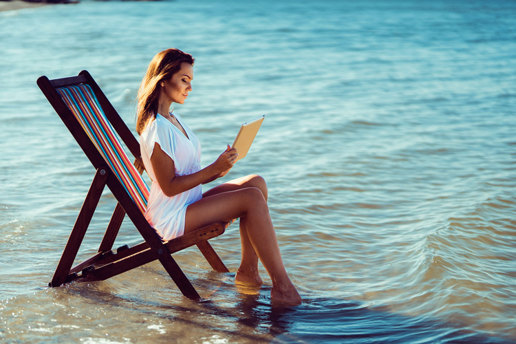 Young woman grounding in ocean water with her journal. Young woman grounding in ocean water with her journal.