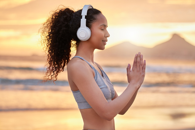 Young African-American woman gives thanks for the beach during a walking meditation. Young African-American woman gives thanks for the beach during a walking meditation.