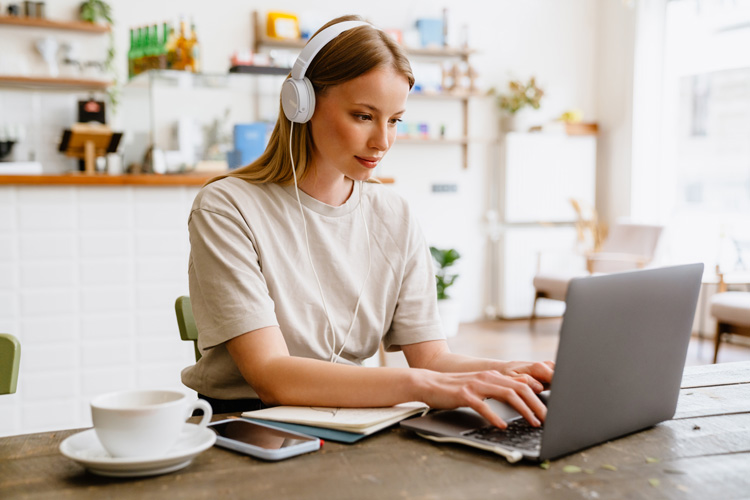 Young female blogger using theta wave binaural beats to benefit her writing. Young female blogger using theta wave binaural beats to benefit her writing.