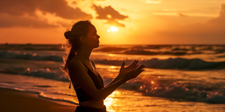 Woman experiencing a mindfulness moment at the seashore during sunset.