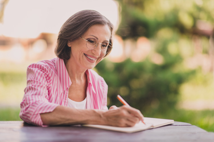 Mature woman writer achieves stronger focus and clarity after meditating outdoors in the morning.