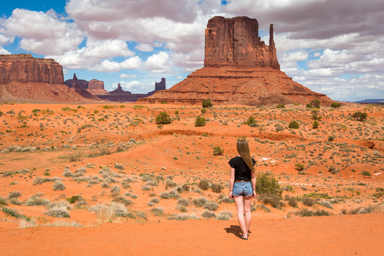 Young woman near the Mittens on a walking meditation in Monument Valley.